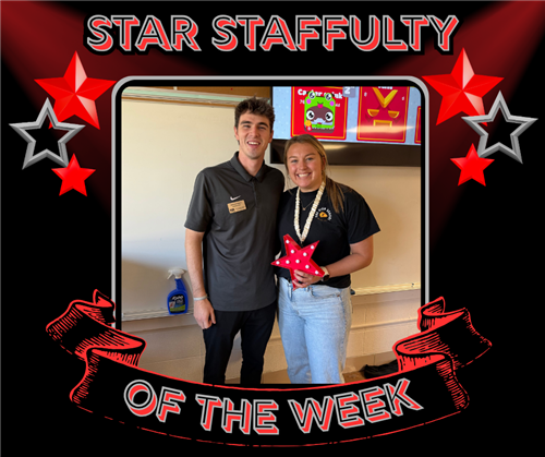 A tall man and a woman pose with the red star of the week. 